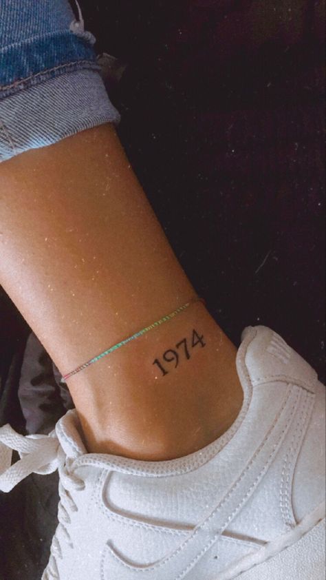 Year Ankle Tattoos For Women, Moms Birth Year Tattoo, Year Date Tattoo Ideas, Floral Date Tattoo, Apartment Number Tattoo, Birth Year Tattoo Placement, Tattoo Ideas With Dates, Date Tattoo Ideas Women, Gimli Tattoo