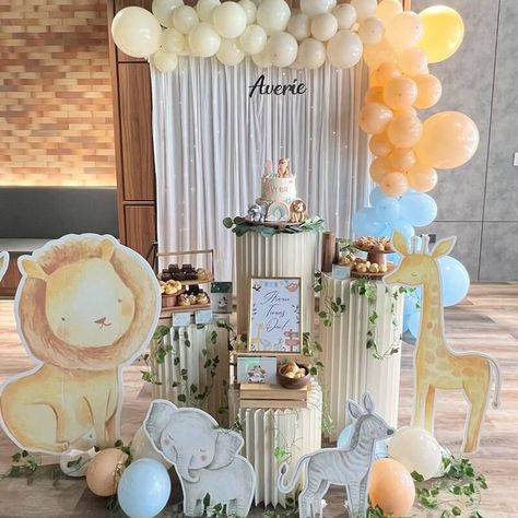 Elevate your little one's first birthday celebration to new heights with a captivating jungle-themed backdrop arrangement. Adorn your backdrop stand with flowing white curtains and illuminate the setup with the soft glow of string lights, creating a chic and modern atmosphere. To infuse a gentle and cheerful touch, opt for pastel-hued balloons. Enhance your table arrangement with dessert stands and lush vines to complete the festive charm, making it a celebration to remember. Jungle Themed Party, Event Decor Ideas, Party Decorations Table, Dessert Stands, Decorations Table, Dessert Stand, Table Arrangement, White Curtains, Charm Making