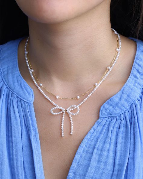 Embrace the bow-tiful blend of classic charm and contemporary design with the Pearl Bow Necklace from Poppy Rose. Playful and feminine, this necklace features white pearls and 14k gold-filled beads, tied together in a dainty bow. Whether styled with a casual sweater and jeans or a sparkly party dress, this necklace is sure to turn heads wherever you go. 14k Gold Filled White Pearl Length: Adjustable 14" - 16" Pearl And Bead Jewelry, Necklace With Pearls And Beads, Pearl Necklace With Bow, White Necklace Beads, Jewellery Craft Ideas, Pearl Ribbon Necklace, Cute Handmade Necklaces, Beaded Necklace With Pearls, Bow Necklace Beads