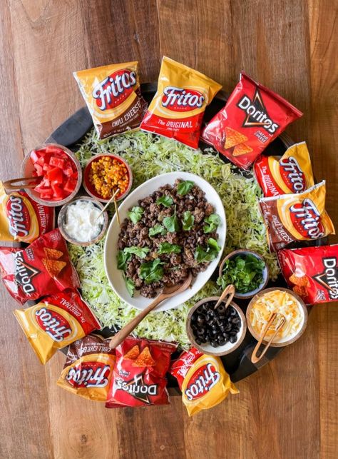 Serve an Epic Walking Taco Board for any party, gathering or potluck. Make taco salads in chip bags. Add toppings and serve on The Big Board. Taco Dip Charcuterie Board, Fall Chili Charcuterie Board, Sandwich Snack Board, Chip Party Ideas, Walking Taco Bar Party Doritos, Chip Bag Tacos, Appetizer Snack Board, Grilling Charcuterie Board, Simple Cheap Charcuterie Board