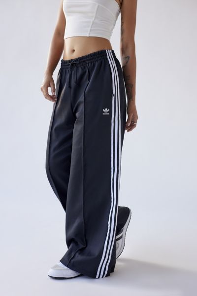 Effortless track pants from Adidas in an oversized fit. Cut with a low-rise and a baggy wide-leg that hits below the ankle. Complete with signature stripes at each side. Features. Classic active pants from adidas in a relaxed silhouette Low-rise fit with an elastic waistband and a super wide-leg Pull-on construction; side pockets Content + Care. 50% Cotton, 43% polyester, 7% spandex Machine wash Imported Size + Fit. Model in Black is 5'8" and wearing size Medium Measurements taken from size Medi Adidas Loose Pants, Adidas Oversized Pants, Low Rise Track Pants, Baggy Sporty Pants, Baggy Adidas Pants Outfit, Adidas Wide Leg Pants Outfit, Adidas Baggy Pants, Wide Leg Track Pants Outfit, Adidas Wide Leg Pants