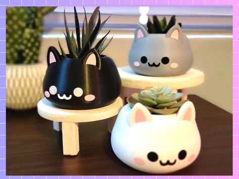 This adorable cat is the perfect plant holder for succulents or small indoor plants! Do you love cats? Are you looking for something to add to that cute aesthetic in a specific room? Then spruce up your plant room with one of 3 variations of this adorable, aesthetically pleasing, cat faced plant holder! Comes in white, black, and gray! The puurrrfect conversation starter for any indoor plant room! Each plant holder has a inner depth of 59mm x 58mm and comes with built in drainage holes at the base! TESTED FOR INDOOR PLANTS ONLY! This planter has not been fully tested for outdoor use in high temperatures. **Color Variations will have default colors for details like faces. If you would like a different color for small details like faces, please message me! **SHIPPING INFO: Each order will be Clay Office Decor, Plant Holder, Cute Plant Pots, Small Indoor Plants, Useful 3d Prints, Cat Plants, 3d Print, Kawaii Cat, Room With Plants