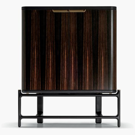 The impeccably crafted, handsome DUO Bar Cabinet (2023) brings the evocative atmosphere of luxury clubs and classic cocktail bars into your own living or dining room. Designer Roberto Lazzeroni infused the romanticism of 1950s Italy into the credenza’s beautiful wood finishes and carefully crafted interiors for Ceccotti Collezioni and Poltrona Frau. The elevated, solid ash cabinet features gently rounded, wenge-stained doors fitted with sleek bronzed metal integrated pulls. It stands on a distinctive, airy wood base with an ebony finish. Open the doors and unobtrusive LED lighting instantly illuminates the cabinet’s contents. The interior is fitted in maple, with multiple storage compartments to showcase prized glassware, bottles, and accessories, including two interior drawers and two ser Sleek Bar Unit, Ash Cabinet, Liquor Cabinet Modern Large, Modern Bar Cabinet Lux, Black Minibar Cabinet, Roche Bobois Bar Cabinet, Hotel Minibar, Bar Cabinet Design, 1950s Italy