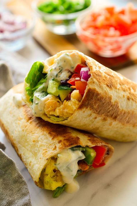 Estos burritos veganos mediterráneos llevan garbanzos machacados, verduras coloridas y una salsa tzatziki vegana con hierbas, pepino y limón. Estos burritos son rápidos y fáciles de hacer, perfectos para preparar de antemano y llevar contigo al trabajo o a la escuela. Mediterranean Wraps, Burritos Recipes, Mediterranean Wrap, Vegan Mediterranean, Vegan Tzatziki, Tzatziki Recipes, Low Carb Wraps, Vegan Burrito, Vegan Wraps