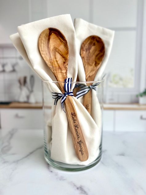 Introducing your new favorite kitchen addition: the Custom-Lake-Name Engraved Olive Wood Spoon and Towel set! This isn't just your average kitchenware - it's a piece of home. Beautifully engraved with your beloved lake, beach, or river name, it's made to bring memories straight into your kitchen. It's a gift that resonates with both men and women, perfect for housewarming or as a lovely hostess present. Imagine commemorating a special time with this personalized kitchen set, made to fit right into your lake house, beach house, or even your cozy little kitchen in the suburbs. Here's what makes this spoon and towel set a cut above the rest: - This custom engraved spoon, carved from Mediterranean olive wood, brings a touch of nature to your kitchen. - The natural (undyed) plain-woven 100% cot Monogram Kitchen Towels, Laser Engraved Wooden Spoons, Bridal Shower Hostess Gifts, Wood Spoon Crafts, Hostess Gift Ideas House Guests, Laser Gift Ideas, Housewarming Gift Ideas For Men, River Name, Towel Gift Ideas