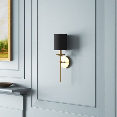 This 1-light wall sconce features a simple sleek look with a flower-like bobeche beneath the linen shade. The finish creates consistent cool. This sconce looks great when used solo or in groupings! 18.5" in height, 5" in width, and extends 6.25" from the wall. Max 60-watt bulb, candelabra size C11 bulb recommended. LED bulb compatible. Damp area rated. Birch Lane™ Finish: Gold, Shade Color: Black Birch Lane™ Olivette 1 - Light Dimmable Wallchiere - Wall Sconces in Gold/Black | Size 18.5" H X 5" Sconces Above Couch, Wall Sconces Living Room, Black Sconces, Wreath Wall Decor, Bathroom Sconces, Sconces Bedroom, Classic Wall, Bedside Lighting, Metal Mirror