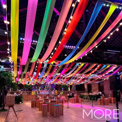 South American Event Theme Decor Streamers Across Ceiling, Carnival Lights Decoration, Ceiling Party Design, Ceiling Event Decor, Church Festival Ideas, Streamers Decorations Ceiling, College Event Decoration Ideas Creative, Streamer Decorations Ideas, Rave Decorations