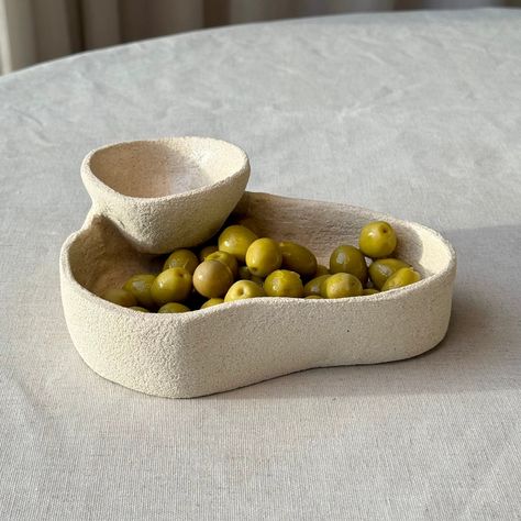 This versatile olive bowl is perfect for cherries, chip and dip, jewellery, or even as a pet bowl. Made from high-fire white stoneware clay, it's glazed inside and raw outside for a Mediterranean touch. Dishwasher and microwave safe. Aprox. width: 15 cm. This piece is entirely handmade, so slight variations from the product image may occur. However, we see all imperfections as perfect 🤍 Dishwasher-safe, but hand-washing recommended. Saleta crafts each piece meticulously, creating a stylish and Ceramic Tapas Dishes, Pottery Small Ideas, Olive Bowl Ceramic, Hand Clay Ideas, Ceramica Gres Ideas, Ideas Con Ceramica, Handbuild Ceramics, Ideas Arcilla, Olive Serving Dish