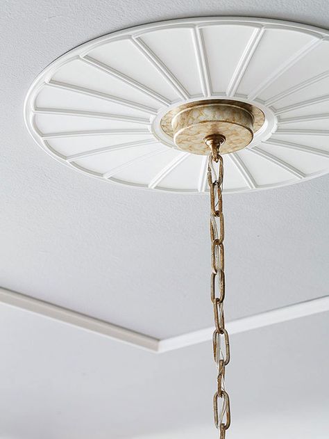 Architectural details are a great way to make a home look expensive. Turn the ceiling into a focal point with this simple trick: Embellish the area around a light fixture's attachment with a lightweight, polyurethane ceiling medallion. Decorative ceiling medallions are available in various sizes and can be painted in your desired hue. How to Install a Ceiling Medallion Decorative Ceiling Panels, Hanging Curtain Rods, Budget Remodel, By Any Means Necessary, Old Lights, Look Expensive, Decorative Ceiling, Exterior Makeover, Blue Curtains