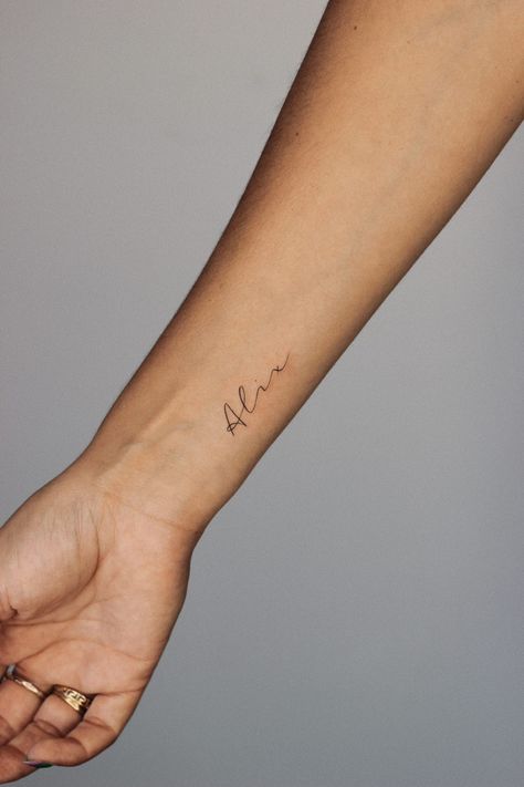 Wrist tattoo small fineline name alix Childs Name Tattoo Placement, Middle Name Tattoo Ideas, Initials Hand Tattoo, Small Wrist Name Tattoo, Lowercase Cursive Letter Tattoo, Tattoo For Daughter Name, Names On Wrist Tattoos, Script Name Tattoo Forearm, Child’s Name Tattoo Dainty