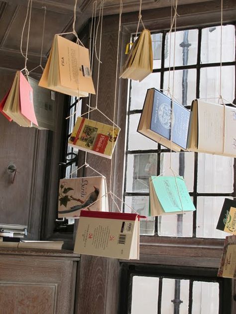 hanging books. Shop Hanging Display, Book Store Shelves Design, Library Exhibition Ideas, Fall Bookstore Window Display, Book Art Display, Hanging Photo Backdrop, Hanging Window Display, Hanging Book Pages, Bookstore Window Display Ideas