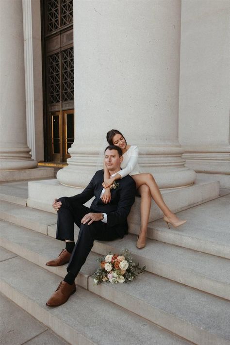 Bride and groom posing for editorial style elopement photos at the Denver Probate Courthouse in Downtown Denver, CO. Bride is wearing a short off shoulder dress by Sarah Seven, with a modern fall bridal bouquet by Beet & Yarrow. Short Off Shoulder Dress, Editorial Elopement, City Engagement Pictures, Fall Bridal Bouquet, City Hall Wedding Photos, Courthouse Wedding Photos, Wedding Portrait Poses, Couple Engagement Pictures, Cute Engagement Photos