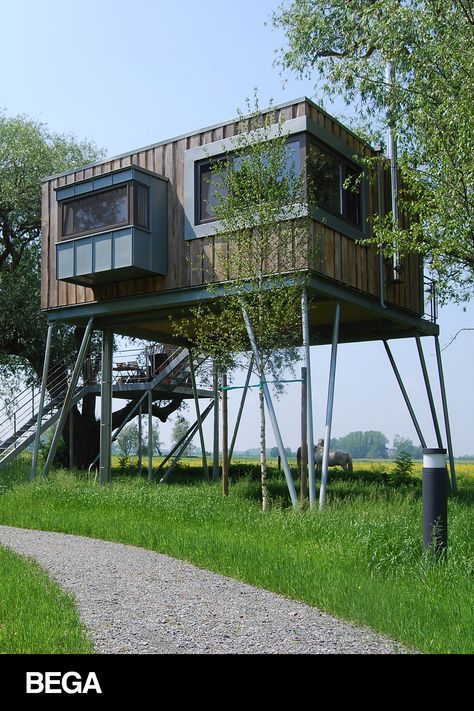 This modern tiny home design is raised on stilts, and provides wide-reaching views of the surrounding nature. Engineered wood paneling combined with metal elements create a modern tree house impression. Learn more about the luminaires featured in this project at bega-us.com. Tree House Aesthetic, Modern House On Stilts, Modern Stilt House, Raised Homes, Stilt Home, Drawing Room Decoration, Modern Tiny Home, Stilt House, Modern Tree House