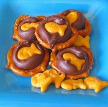 Chocolate, gold fish, and pretzels for a sweet ocean snack.  (I would probably use white chocolate with blue food coloring.) Beach Birthday Party Food Ideas, Gone Fishing Birthday Party Food, Fish Snacks For Kids, Ocean Themed Party Food, Ocean Snacks, Goldfish Snack, Hersey Kisses, Vbs Snacks, Ocean Ideas