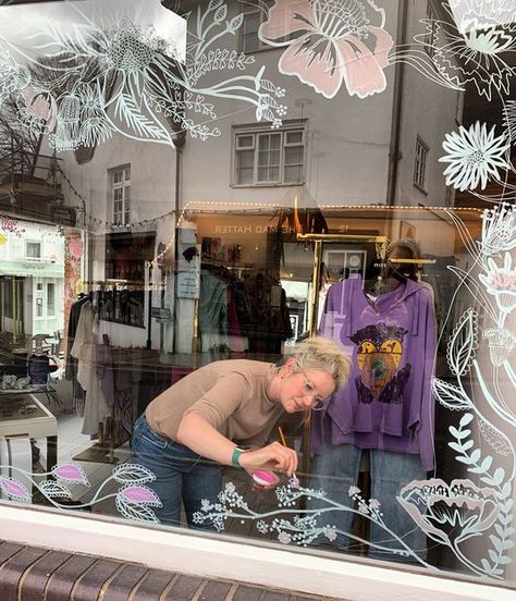 SARAH-VM-Interior-Stylist-Artist on Instagram: "FREEHAND ILLUSTRATION Loved working back in Guildford today. The lovely Kim from @mistyandclaridge sells the most beautiful designs. She wanted a bespoke design wrapping around two windows in her boutique. All designs are drawn inside for longevity, freehand, and painted in a custom colour palette to match the new Spring/summer collections arriving. Can’t wait to show you the final result 💕🌸🌿 #freehandillustration #illustration #illustratio Boutique Window Painting Ideas, Spring Painted Windows, Shop Front Design Store Displays, Painted Store Windows, Storefront Window Painting, Spring Window Art, Summer Window Painting, Window Display Design Creative, Spring Window Painting