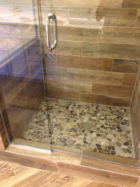 Showers With River Rock Floors, Shower Tile Ideas Wood Look, Cream Color Shower Tile, Pebble Shower Floor River Rocks, River Rock Shower Ideas, Pebble Floor Shower Ideas, Pebbles Bathroom, Wood Tile Shower Ideas, River Rock Shower Floor