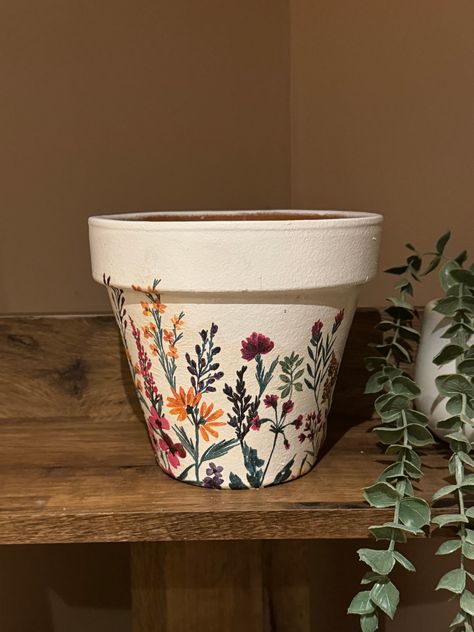 A Gorgeous hand-decorated Terrecota pot decoupaged in a beautiful Floral meadow design. Approximate size - 4.5 inch diameter  to clean simply wipe with a damp cloth. As with all of my products, they are hand decorated so no two items are exactly the same. The surface will not be completely smooth due to the decoupage crafting process. Coated with a weather and UV proof varnish so is suitable for indoor and outdoor use. Hand Painted Pots Terra Cotta, Cottage Core Plant Pots, Diy Plant Pot Decoration, Diy Plant Pot Painting Ideas, Painting Object Ideas, Painted Flower Pots Aesthetic, Decorated Terra Cotta Pots, Decoupage Plant Pots, Cute Pot Designs