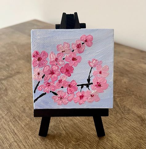 Hand painted 4x4in canvas in acrylics. Featuring pink cherry blossom branch. Small easel included. Mini Canvas Paintings Cute, Double Canvas Painting Ideas Abstract, Easy Quick Paintings Ideas, Easy Cherry Blossom Painting, What To Draw On A Canvas, Poster Colour Painting Ideas, Easy Girly Paintings, Cherry Blossom Acrylic Painting Easy, Flower Paintings Easy