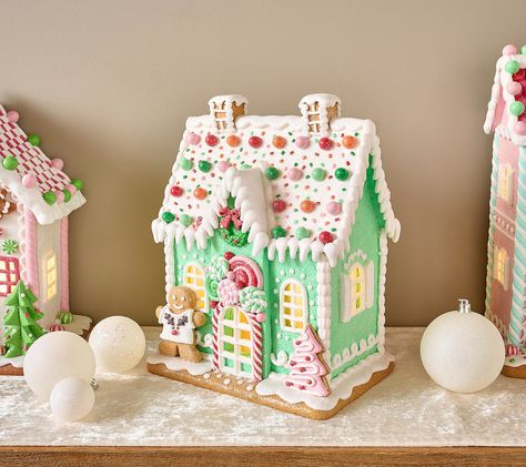 The sweetest part of the holidays? Celebrating with family and friends! But this illuminated gingerbread house -- overflowing with piped pastel details, peppermint candies, and not-so-cookie-cutter accents -- is a close second. From the Valerie Parr Hill Collection. Pastel Christmas Village Houses, Gingerbread House Pastel, Pastel Christmas Village, Rainbow Gingerbread House, Girly Gingerbread House, Gingerbread Windmill, Painted Gingerbread Houses, Pastel Gingerbread Christmas Decor, Gingerbread House Christmas Decorations