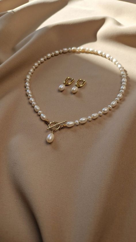 Elevate her neckline with our stunning natural pearl jewelry set. This gorgeous freshwater pearl toggle necklace adorned with a single radiant pearl, symbolizes purity and elegance. The toggle design adds a contemporary twist to this timeless piece, making it a versatile addition to her jewelry collection Looking for the perfect Mother's Day gift for mom or anniversary gift for wife, or special gift for any other important women in your life. Our real pearl jewelry set speaks volumes of love and Pearl Set Designs, Pearl Sets Jewellery, Pearl Necklace Designs Unique, Real Pearl Jewellery, Pearl Necklace And Earrings, Natural Pearl Jewelry, Pearl Jewelry Set, Natural Pearl Necklace, Necklace Packaging