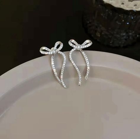 These dangle bow earrings feature a “ribbon” that hangs behind the ear to give a dramatic effect. Hanging Earrings Silver, Ribbon Jewellery, Bow Earrings Silver, Silver Bow Earrings, Winter Accessories Jewelry, Bow Earring, Ribbon Earrings, Silver Earring, Silver Dangle Earrings