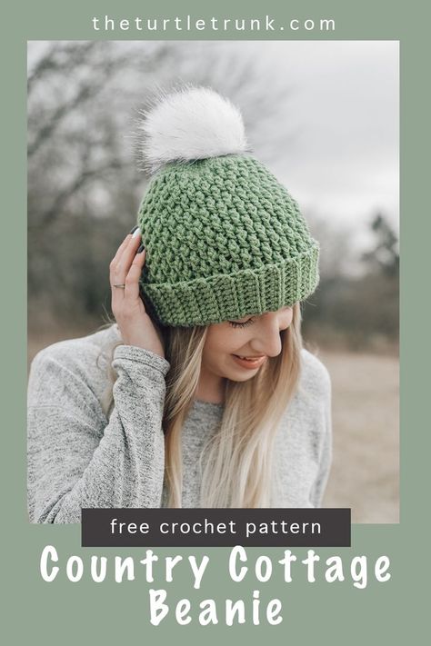 Women standing outside wearing a green, crochet beanie with white pom pom.