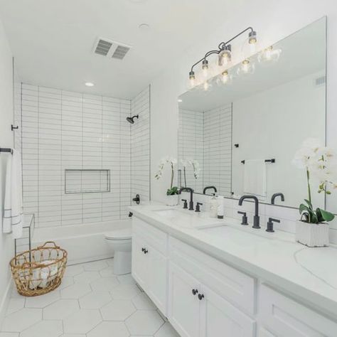 These Bathrooms Prove Hexagon Floor Tile Is Stunning Big White Subway Tile Bathroom, All White Subway Tile Bathroom, Classic Bathroom Shower Tile, White Bathroom Black Floor, White Bathroom Black Accents, White Tiled Showers, White Subway Tile Bathroom Tub, 4x12 Subway Tile Bathroom, Bathroom Floor And Shower Tile Matching