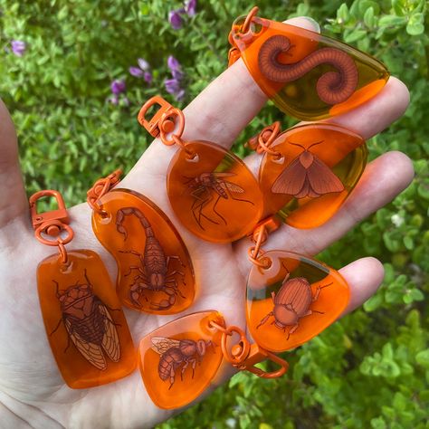 Acrylic keychains made to resemble amber fossils! These are orange acrylic with double sided epoxy coatings. Between 1.5 and 2 inches Funky Keychains, Acrylic Keychain Ideas, Sibling Halloween Costumes, Bug Gifts, Accessory Inspo, Bug Art, Amber Fossils, Acrylic Keychains, Acrylic Keychain