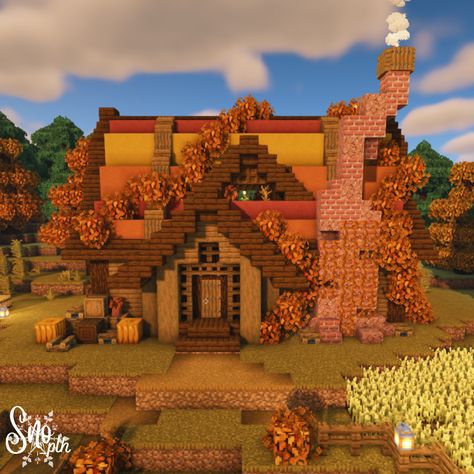 An autumn cottage in Minecraft. A warm chimney made of brick and granite on the front with smoke slowly emulating from the top. A red, orange, and yellow festive autumn roof shrouded in orange leaves and lined with dark oak. Cozy accents of window boxes, barrels, and pumpkins let you know this is your home for the autumn season. Pumpkin patches and small wheat crop fields frame either side of the house. Mincraft Fall House, Cute Fall Minecraft Houses, Minecraft Fall Cottage, Minecraft Halloween Banner Designs, Halloween Themed Minecraft House, Orange Minecraft Aesthetic, Minecraft Fall Trees, Autumn Minecraft Aesthetic, Aesthetic Fall Minecraft Builds