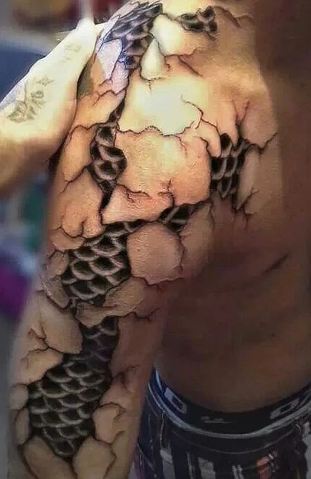 An unusual take on the dragon body art trend is the scale tattoo. Your tattooer will use techniques similar to special-effects make-up artists to create the illusion that you have a layer of scales beneath your real skin. Artistic tears and cracks can also be added for extra impact. When you choose this tattoo style, you are hinting at the beast within. A scale inking tells others that you identify strongly with the characteristics of a dragon – fierce and powerful. 3d Dragon Tattoo, Tatoo 3d, Make Temporary Tattoo, Molecule Tattoo, Dragon Tattoos For Men, Skin Tattoo, Scale Tattoo, Kunst Tattoos, Tattoo Trend