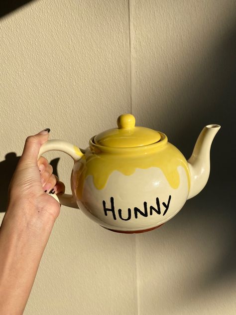 A cream colored tea pot with a honey drip effect on the rim. With the words “Hunny”. Winnie the Pooh Inspired tea pot. Tea Pot Clay Ideas, Tea Pot Pottery Ideas, Pottery Painting Ideas Teapot, Pottery Tea Pot Ideas, Tea Pot Pottery Painting Ideas, Winnie The Pooh Pottery Painting, Painted Teapot Ideas, Teapot Design Ideas, Ceramics Teapot Ideas