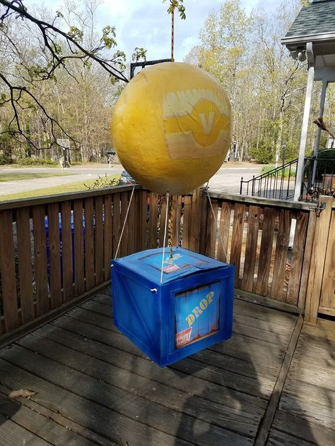 Fornite supply drop pinata.    Balloon is made out of paper mache applied to a large balloon.  Spray painted yellow and V logo printed and glued on.  Box made out of lightweight cardboard box with additional strips of cardboard glued on for edging.  Spray painted in two shades of blue.  Drop box images printed and glued on four sides.  One thick rope connects from the box through the top of the balloon to hang from.  Four smaller ropes connect the balloon to the box. Fortnite Party Ideas, Fortnite Party, Nerf Party, Batman Party, Video Games Birthday, 9th Birthday Parties, 10th Birthday Parties, Birthday Party Planning, 12th Birthday