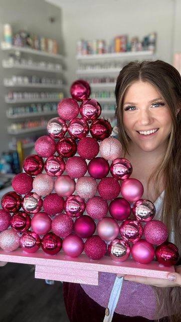 First, grab a few pieces of scrap wood/mdf and nail them together. 🪵 Next, spray paint the base your desired color. Tanna chose pink! 💖 Glitter is optional! ✨ Finally, use your hot glue gun to glue your ornaments to the base and continue stacking until you reach the top! 🔝 Get into the holiday spirit by crafting a unique and festive decor that will dazzle your guests. 🤩 What’s your go-to DIY Christmas craft that never fails to bring holiday cheer into your home? Pink Christmas Decorations Outdoor, Pink Christmas Diy Decoration, Pink Christmas Ornaments Diy, Diy Pink Ornaments, Diy Pink Christmas Decorations, Pink Christmas Decorations Diy, Pink Christmas Table Decor, Pink Christmas Diy, Turquoise Christmas Decor