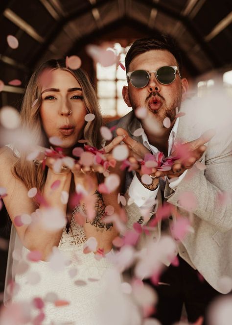 The bride and groom blowing pink, white and red confetti at their wedding in Wales Wedding Photos Funny Creative, Wedding Idea Photoshoot, Cheesy Wedding Photos, Fun Wedding Photography Ideas, Wedding Photos Confetti, Unique Couple Wedding Photos, Wedding Photos In A Bar, Funky Wedding Photos, Disco Wedding Photos