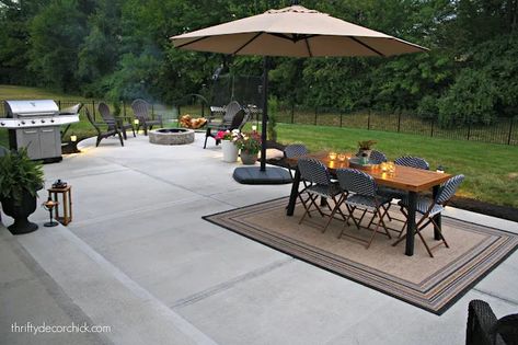 Our outdoor living space: The patio reveal | Thrifty Decor Chick | Thrifty DIY, Decor and Organizing Backyard Patio Designs With Fire Pit, Curved Concrete Patio, Simple Concrete Patio, Concrete Backyard Ideas, Outdoor Concrete Patio, Fire Pit With Seating, Outdoor Furniture Ideas Backyards, Patio Plans, Cement Patio