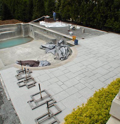 pool deck was poured with a white Portland mix with titanium dioxide. “Since the pool deck mix itself was white, we did not rely on stains to achieve the coloring.” After the topping was poured and stamped, the joints were filled with a white grout, creating the white-on-white effect. Concrete Patio Planters, Modern Stamped Concrete Patio Ideas, White Concrete Pool, Pool Decking Concrete, Stamped Concrete Patio Designs, Cement Pools, Concrete Pool Deck, Stamped Concrete Driveway, Concrete Stain Patio