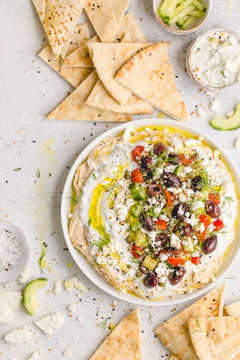 Greek Dip with Hummus and Tzatziki - a flavor-packed appetizer you can make ahead of time! One layer of smooth, savory hummus; followed by a layer of cool, herby tzatziki; and finished with toppings like feta cheese, chopped fresh cucumbers, sweet tomatoes, briney capers, and olives. Greek Dip, Fingerfood Party, Mediterranean Diet Recipes, Dip Recipes, Greek Recipes, Mediterranean Recipes, Clean Eating Snacks, Organic Recipes, Artichoke