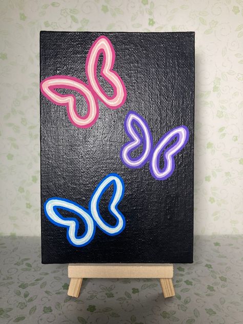 3 butterfly painting with acrylic canvas on a6 x 4 in. Canvas board. Ideas For A Black Canvas, Stuff To Paint On A Black Canvas, Spray Paint Butterfly, Split Canvas Painting Ideas Easy, Half Butterfly Painting On Canvas, Neon Butterfly Painting, Painting Ideas On Wooden Boards, Aesthetic Simple Painting Ideas, Sister Canvas Painting Ideas