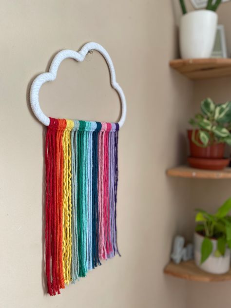 Rainbow cloud wall hanging Eco friendly materials Do you want to bring some fun, boho flair to your nursery? Look no further than this vibrant macrame rainbow cloud wall hanging! Handmade with recycled cotton in a stunning rainbow colour palette, it's the perfect way to add a splash of colour to your little one's space. This rainbow cloud hanging, nursery wall decor, is made using a wooden cloud cutout (from another small business), wrapped in white recycled cotton cord, with rainbow hanging cor Classroom Ceiling Decorations, Rainbow Colour Palette, Rainbow Decor Bedroom, Cloud Hanging, Rainbow Room Decor, Cloud Decor, Simple Wall Paintings, Rainbow Lamp, Rainbow Hanging