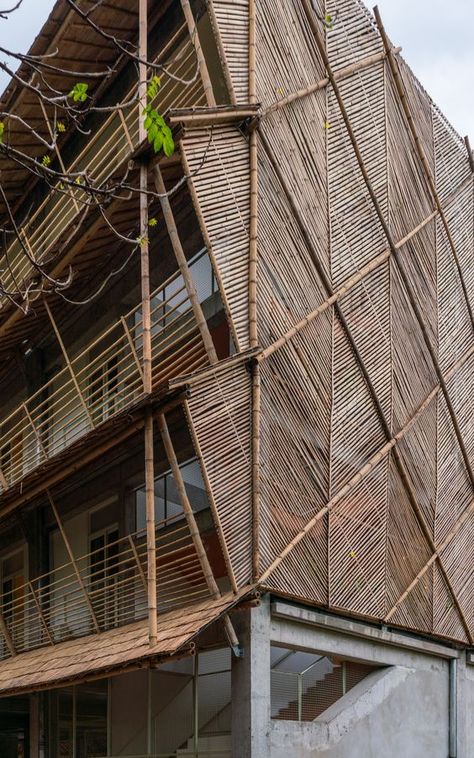 Takhmau Boarding School by Bloom Architecture combines a robust concrete skeleton with an organic bamboo skin, that filters the tropical sun. The building is designed with sustainability as its main criteria. A concrete skeleton was chosen for its sturdiness, and a bamboo enclosure is made as transparent and porous as possible to prioritise natural ventilation while providing intimacy for the students. Photo Credits: Antoine Raab Bamboo Facade Architecture, Bamboo And Concrete Architecture, Nature Architecture Concept, Bamboo Architecture Design, Bamboo Facade, Tropical Building, Organic Architecture Concept, Houses In Germany, Bamboo Building