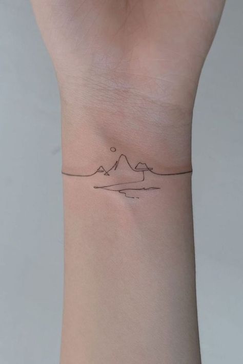 Line Art Landscape2 Minimalistic wrist tattoo featuring a fine line mountain range with a sun and a wave, representing nature and adventure. | Sky Rye Design Tattoos For Mountain Lovers, Nature Tattoos Minimalist, Mountain Tattoo On Wrist, Mountain Line Art Tattoo, Wrist Mountain Tattoo, Minimalist Tattoo Nature, Mountain Minimalist Tattoo, Nature Fine Line Tattoo, Mountain Fine Line Tattoo