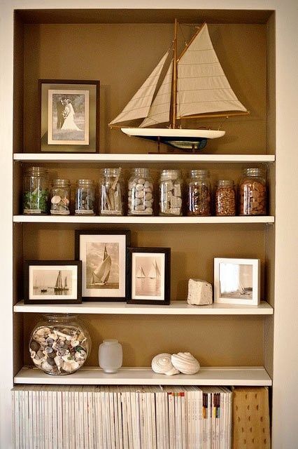 Coastal home with sailboat decor and mason jar storage. Rock Decorating Ideas Display, Jar Collection Display Ideas, Stone Collection Display Ideas, Aquarium Shelves, Displaying Rocks, How To Display Rocks, Rock Display Ideas, Jars Organization, Display Rocks