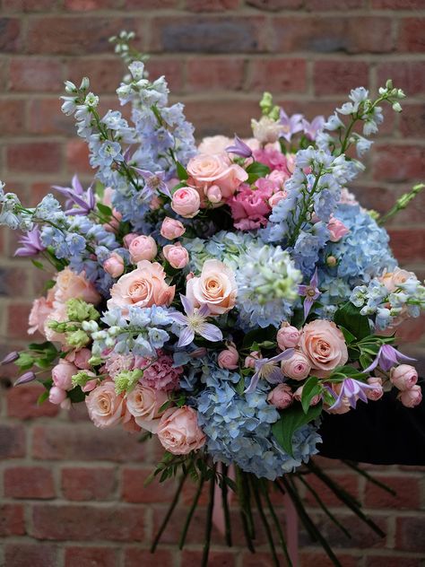 Pastel blush of pink spray roses mixed along side beautiful large heads of pearl coral colour rose and Ice blue delphinium. Including an enlightening range of light blue hydrangea complementing the fluffy tutu shape of Lisianthus and finishing with the touch of lilac colour clematis. Refreshing, colourful and perfect in spring or summer. Image shows size: Statement The flower bouquet will be wrapped in a complimentary wrapping and a bouquet bag with water. To include a vase with your bouquet, kindly select one from our Vase Collection. We kindly request that you order this bouquet at least 1 day in advance to ensure we hand-pick the finest flowers for you. Lilac And Blue Bouquet, Yellow Pink Blue Flower Arrangement, Colorful Hydrangea Bouquet, Pastel Flowers Bouquet, Pink And Powder Blue Wedding, Colourful Flower Arrangements, Blue And Pink Flower Arrangements, Pink And Blue Flower Arrangements, Blue And Pink Bouquet