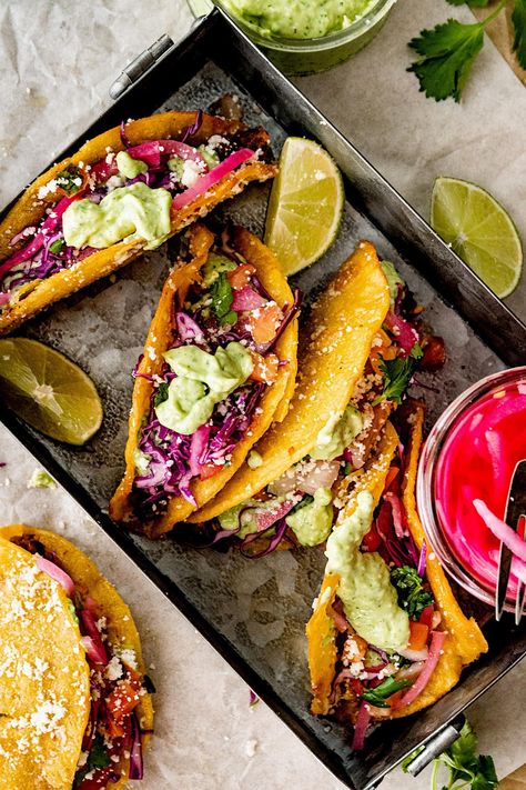 Black Bean Tacos served in crispy taco shells with creamy avocado sauce, pickled red onions, shredded cabbage, and cheese. Cabbage And Cheese, Cabbage Tacos, Crispy Taco Shells, Fresh Corn Salad, Dinner Favorites, Creamy Avocado Sauce, Black Bean Tacos, Taco Shells, Bean Tacos