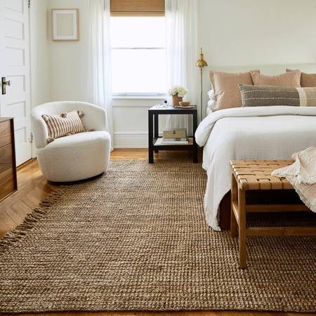 No matter the decor or flooring material in your bedroom, a rug can act as a grounding piece. A good area rug will help set your style, give you a war... | Play on Neutrals with a Chunky Jute Rug Jute Rug Bedroom, Jute Rug Living Room, Farmhouse Interior, Natural Fiber Rugs, Rugs Usa, Sisal Rug, Bedroom Aesthetic, Jute Rug, White Rug