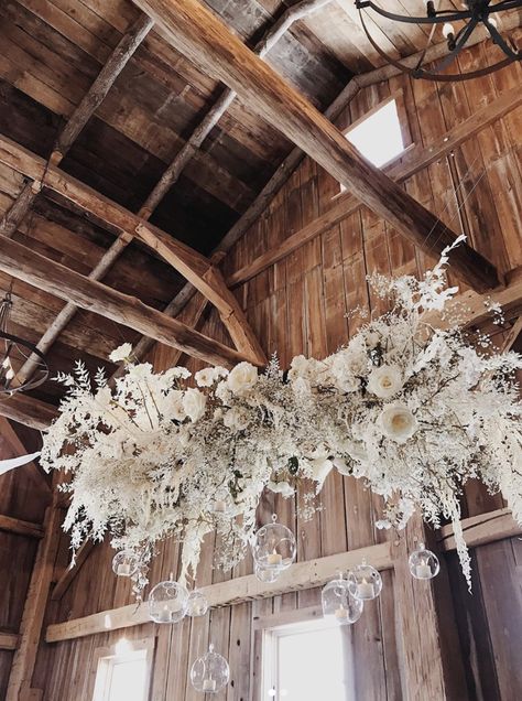 Dried Floral Chandelier by New Creations Flower Co., Cabin Wedding (Baby's Breath, Bleached Ruscus, White Roses, Floating Orb Candles, Driftwood, Bleached Fern) Wedding Floating Flowers, Wedding Flower Installations, Floating Flowers Wedding, Floating Floral Arrangements, Dried Flower Chandelier, White Hanging Flowers, Flowers Hanging From Beams Wedding, Pampas Chandelier Wedding, Wedding Chandelier Ideas