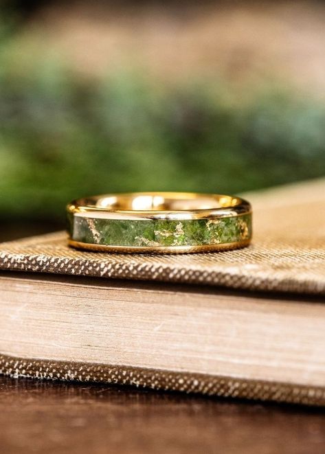 custom 18k yellow gold ring green imperial diopside gold flakes inlay laying on book rustic and main Non Traditional Wedding Bands Men, Mens Alternative Wedding Band, Peridot Wedding Band Men, Peridot Ring Men, Peridot Ring For Men, Unique Engagement Rings Men, Wedding Rings For Men Unique, Unique Rings For Men, Ring Designs For Men