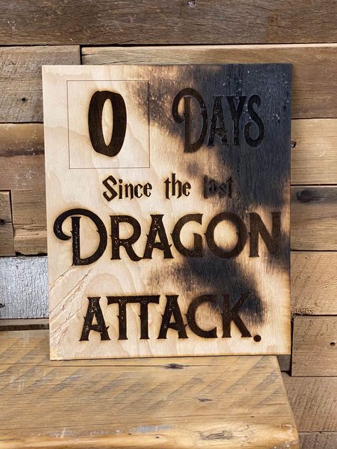 "It's only been zero days since last dragon attack! This wall sign would look perfect in any game room. Your companions should know that dragon attacks are a real thing to look out for... especially on game night! Burned edges and claw marks give it a little authentic feel. Your workplace sign will be 10x12\". Stay aware of workplace dangers! *each sign will be slightly different. Scratches and burn marks are random dragon markings." Mtg Game Room, Dnd House Decor, Dnd Gift Ideas Diy, Geeky House Decor, D&d Room Decor, Nerd Decor Home, Dungeon Room Ideas, Dragon Halloween Decorations, Dnd Home Decor