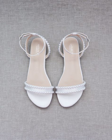 "Classy satin flat sandals with a pearls and ankle strap. Effortless yet adorable to wear on your favorite occasion. Can be pair with dress or casual look. DETAILS: COLORS AVAILABLE: White, Ivory UPPER: Synthetic upper and lining MATERIALS: Mandmade outsole STYLE NAME: MADDY Not sure of which size to purchase? Shoes measurements are as follow: (Please note measurements taken the length of inside of shoe from toe to heel) KIDS SIZE: Size 9 - 7\" Size 10 - 7.20\" Size 11 - 7.30\" Size 12 - 7.50\" Homecoming Shoes Flats White, Cheap White Wedding Sandals, White Sandals Flat Wedding, Silver Sandals Flat, White Flat Wedding Shoes For Bridal Shower, Prom Shoes Flats, Elegant White Flat Wedding Shoes, Flat Wedding Shoes For Bride, Prom Flats