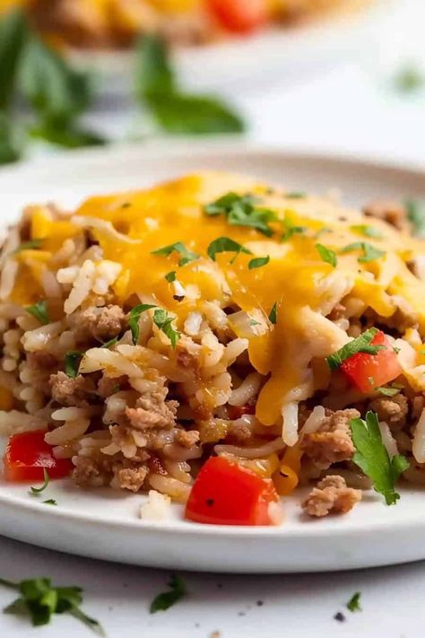 A generous serving of Ground Turkey and Rice, neatly plated on a crisp white dish, showcasing the rich blend of seasoned ground turkey and fluffy rice, all beautifully crowned with a layer of melted cheese. Ground Turkey And Rice, Seasoned Ground Turkey, Ground Turkey Casserole, Turkey And Rice, Ground Turkey Recipes Easy, Chicken Broccoli Stir Fry, Turkey Rice, Gluten Free Turkey, Skillet Dinner Recipes